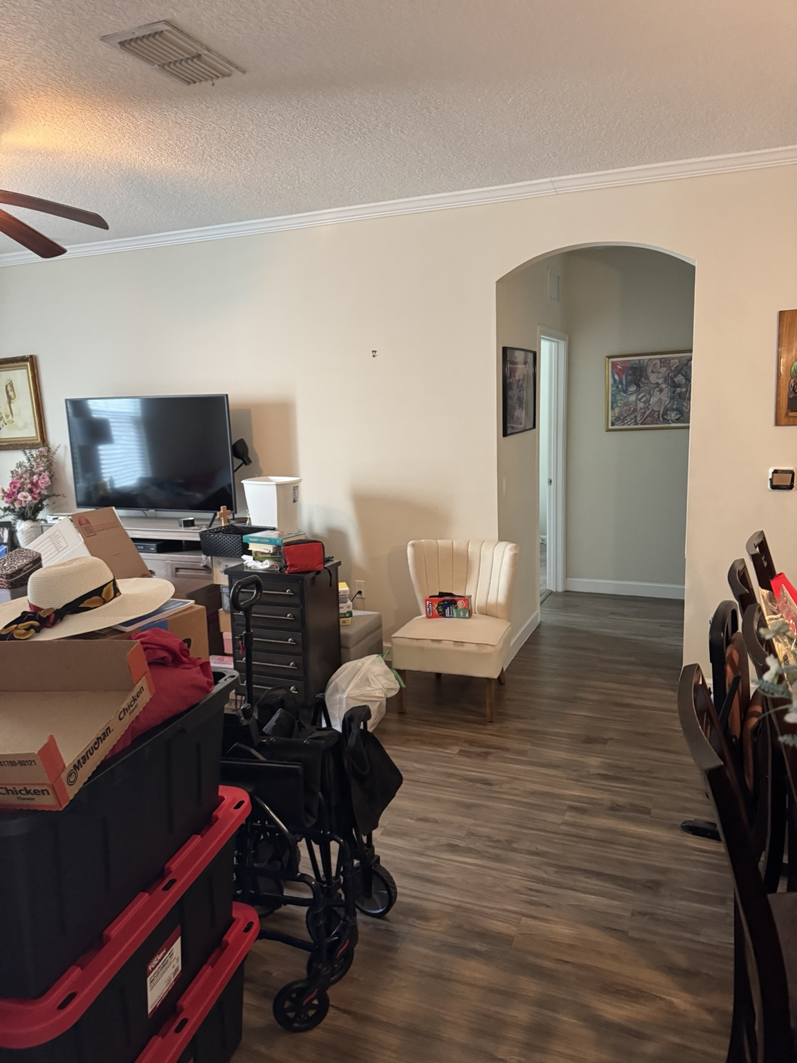 Condo dining and living area packed with storage totes, boxes and mobility equipment before removal