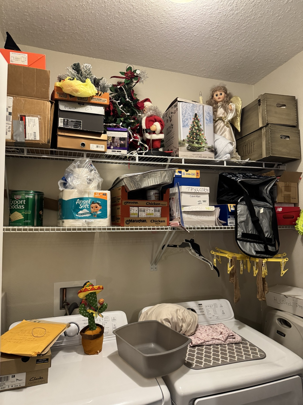 Laundry room wire shelving stacked with boxes, holiday decorations and household supplies